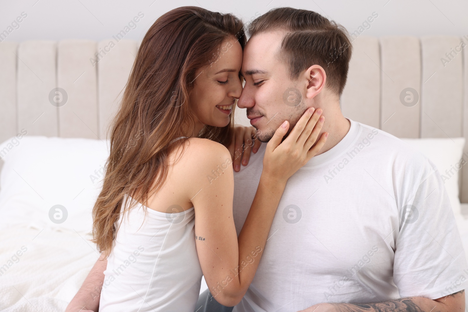 Photo of Happy couple spending time together on bed at home