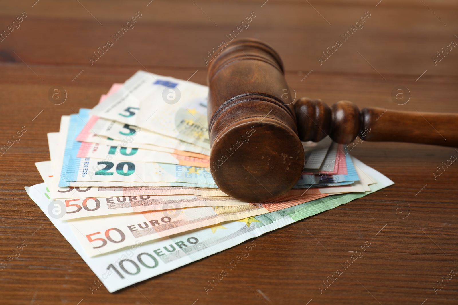 Photo of Alimony. Judge's gavel and money on wooden table, closeup