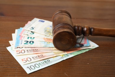 Alimony. Judge's gavel and money on wooden table, closeup