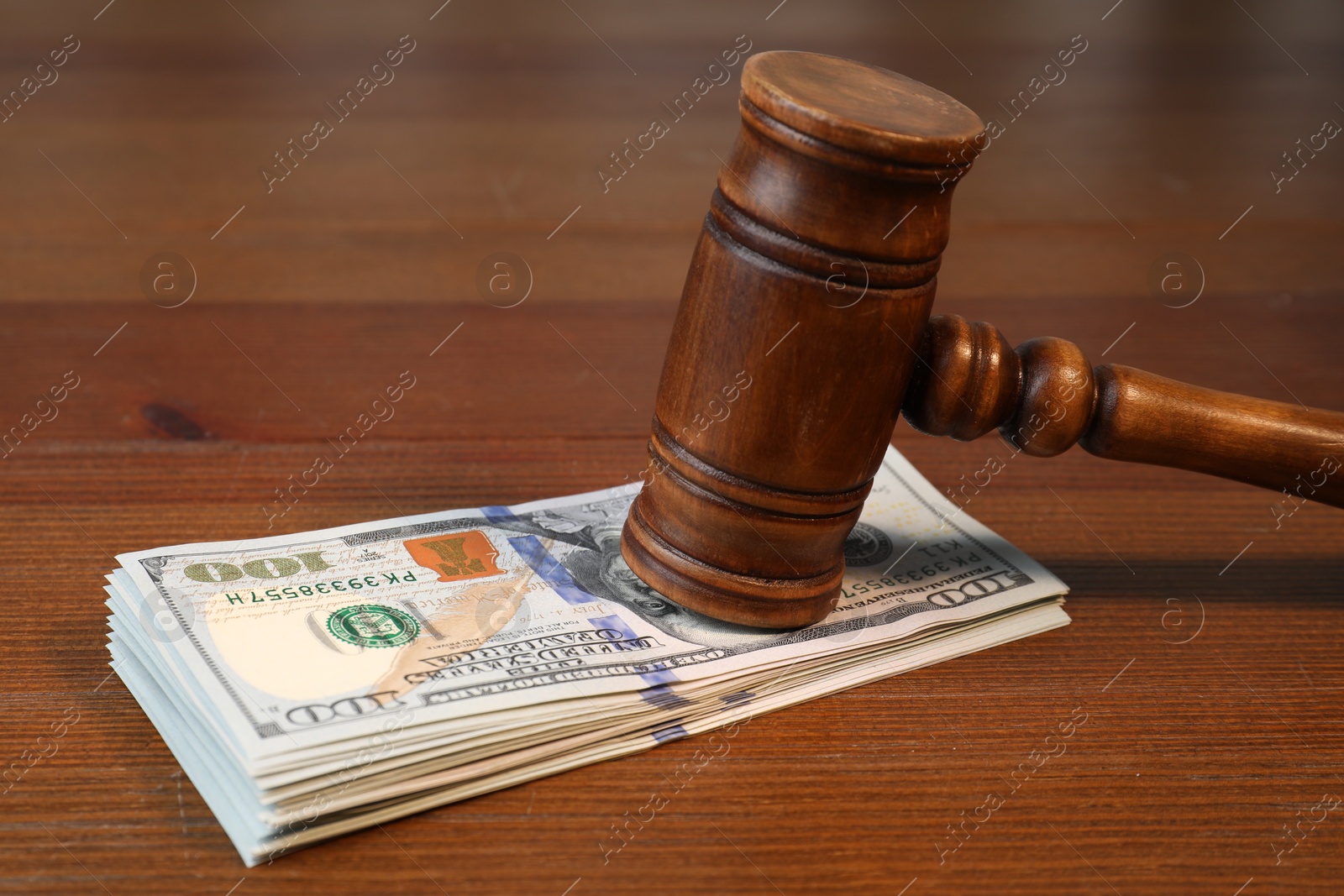 Photo of Alimony. Judge's gavel and stack of money on wooden table, closeup