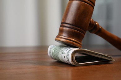 Photo of Alimony. Judge's gavel and folded money on wooden table, closeup. Space for text