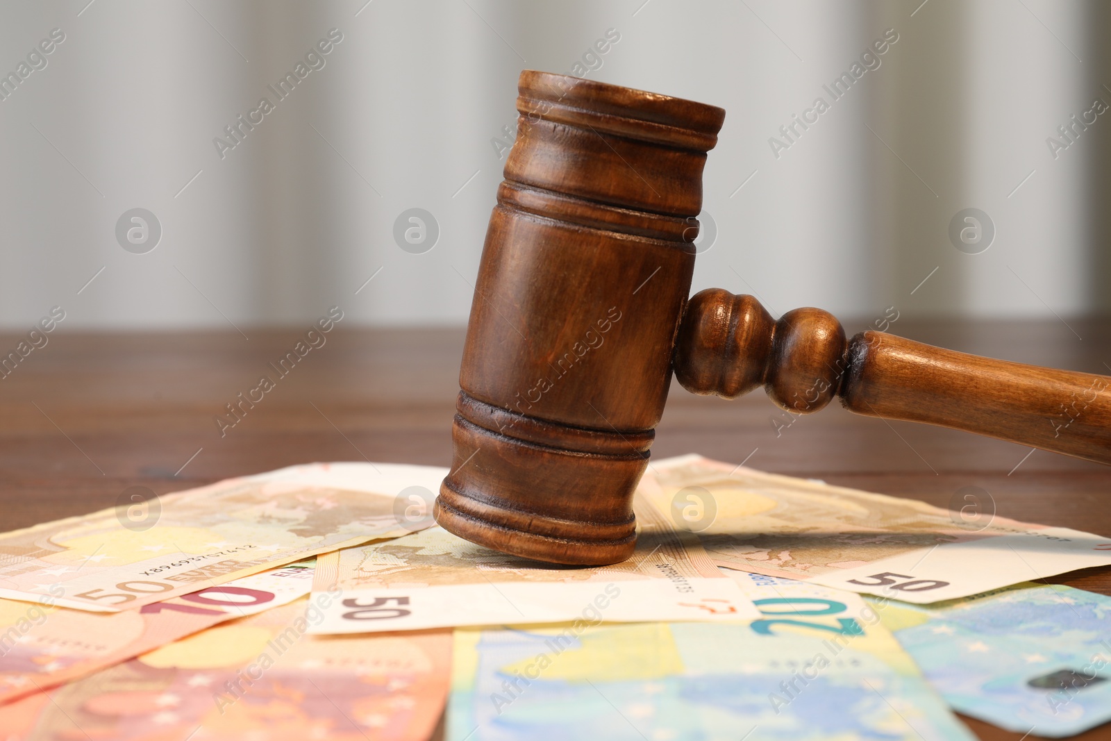 Photo of Alimony. Judge's gavel and pile of money on table, closeup