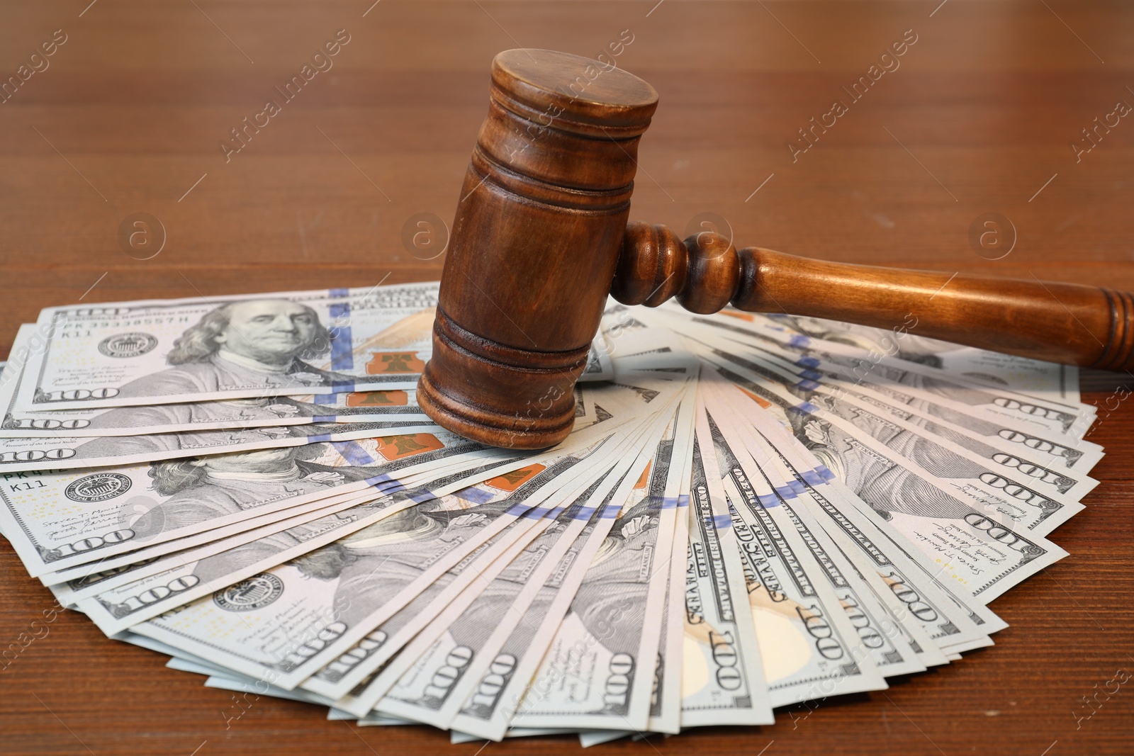 Photo of Alimony. Judge's gavel and pile of money on wooden table, closeup