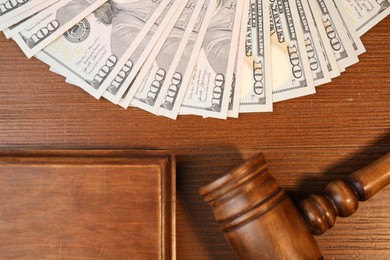 Photo of Alimony. Money, judge's gavel and sound block on wooden table, flat lay