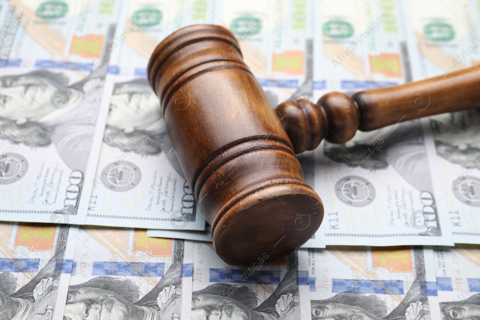 Photo of Alimony. Judge's gavel on dollar banknotes, closeup