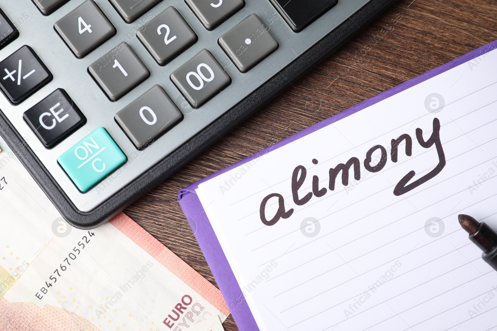 Photo of Notebook with word Alimony, euro banknotes, felt pen and calculator on wooden table, top view