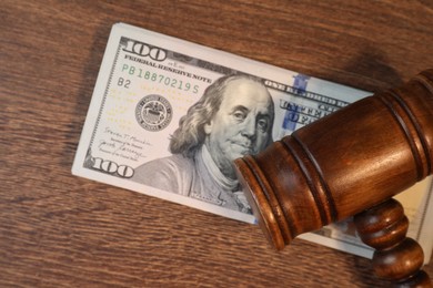 Alimony. Gavel and dollar banknotes on wooden table, top view