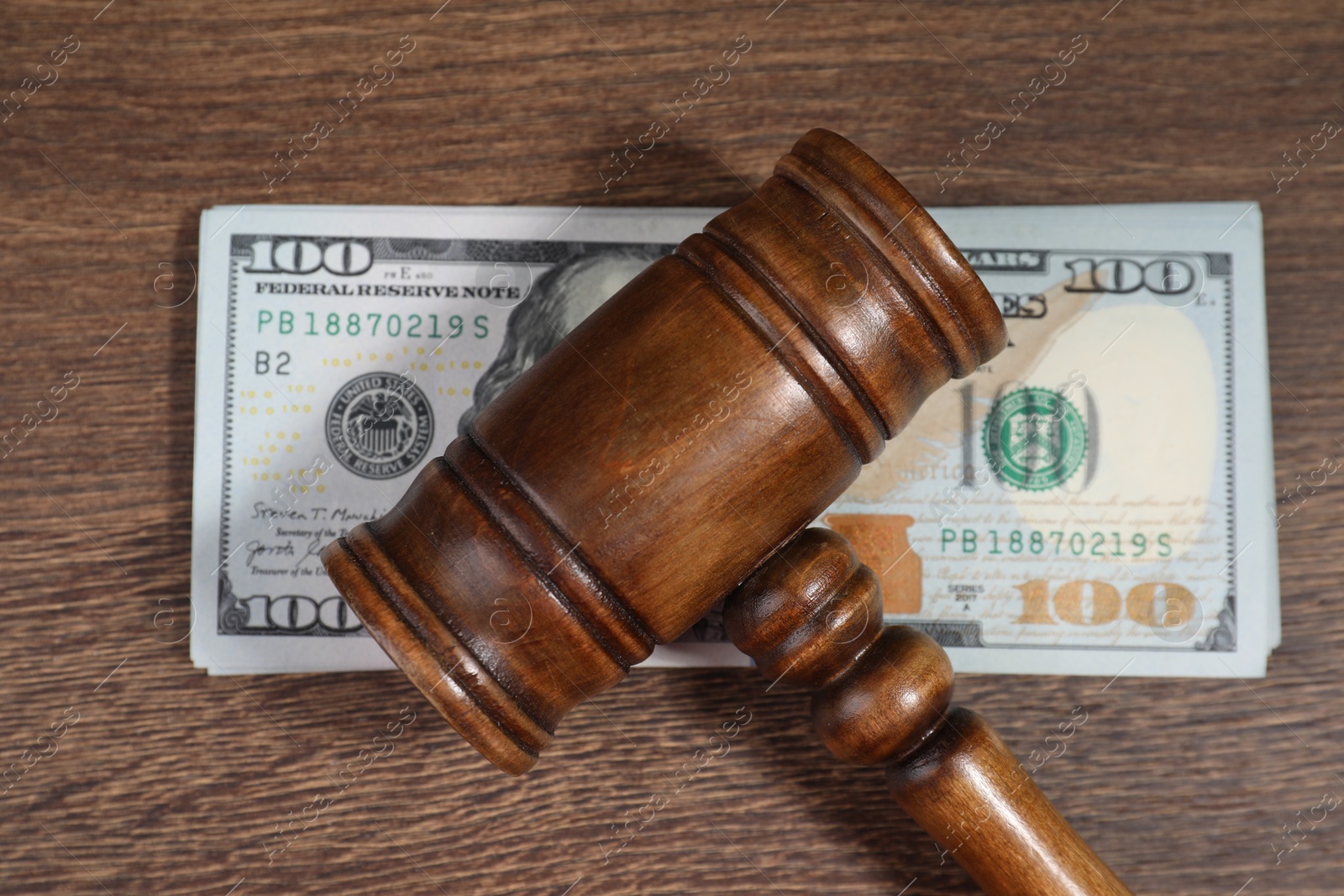 Photo of Alimony. Gavel and dollar banknotes on wooden table, top view