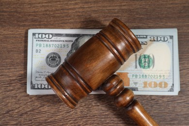 Alimony. Gavel and dollar banknotes on wooden table, top view