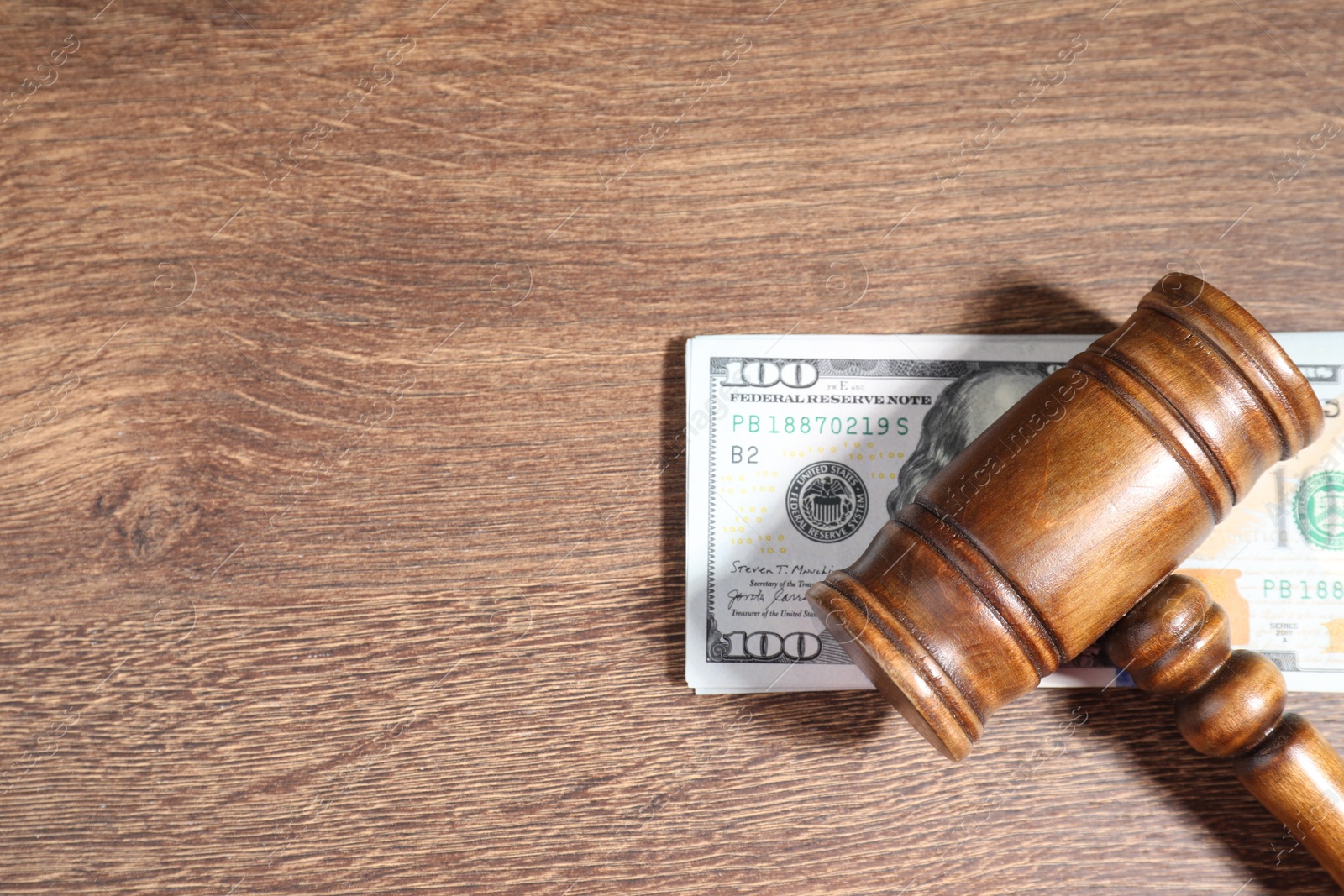 Photo of Alimony. Gavel and dollar banknotes on wooden table, top view