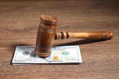 Alimony. Gavel and dollar banknotes on wooden table, closeup