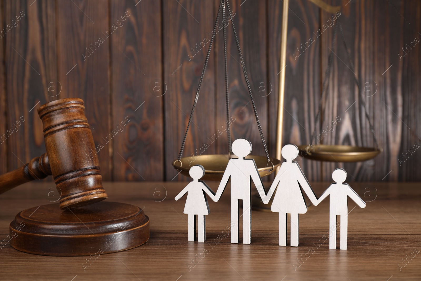 Photo of Alimony. Figures of family, gavel and scales on wooden table