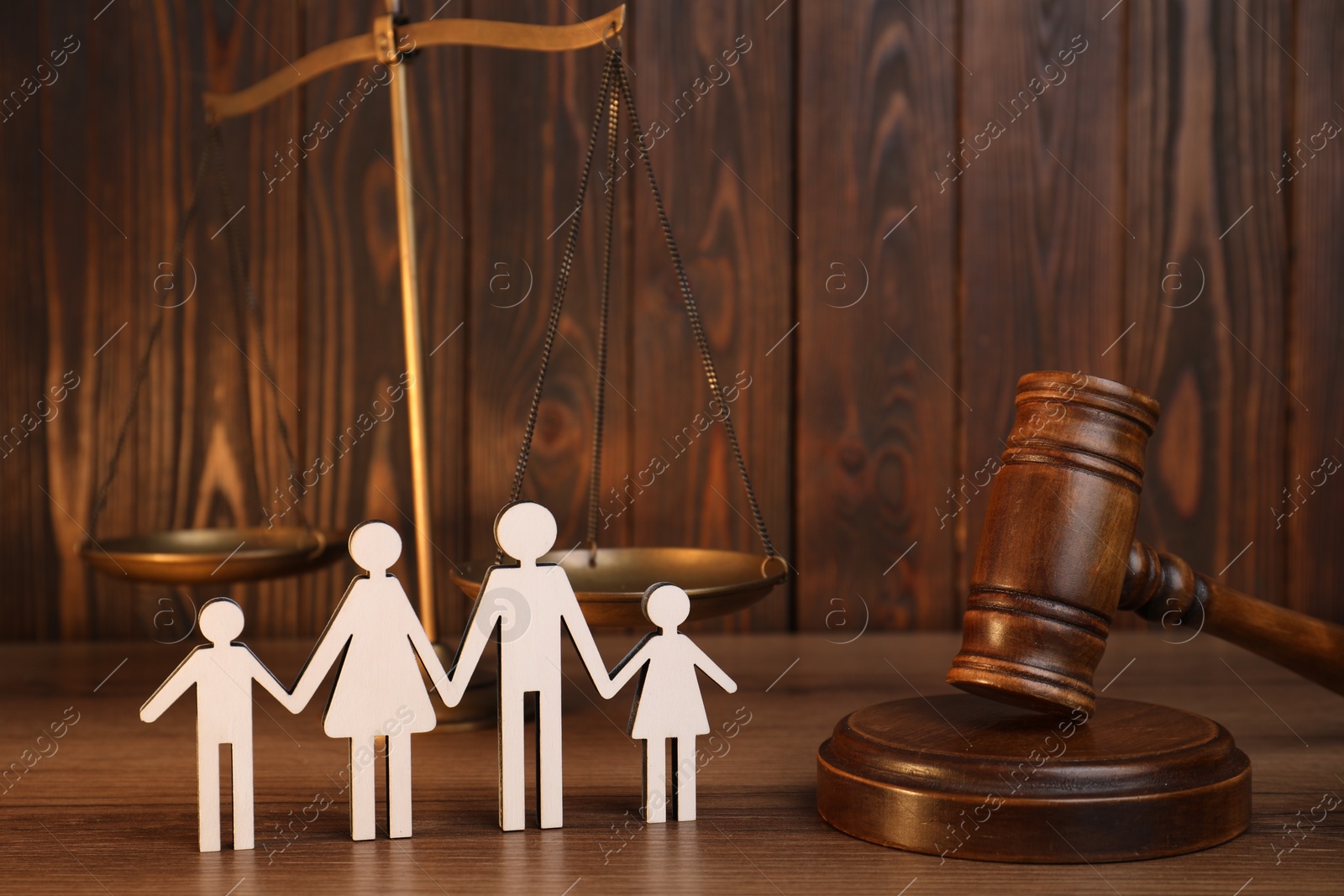 Photo of Alimony. Figures of family, gavel and scales on wooden table