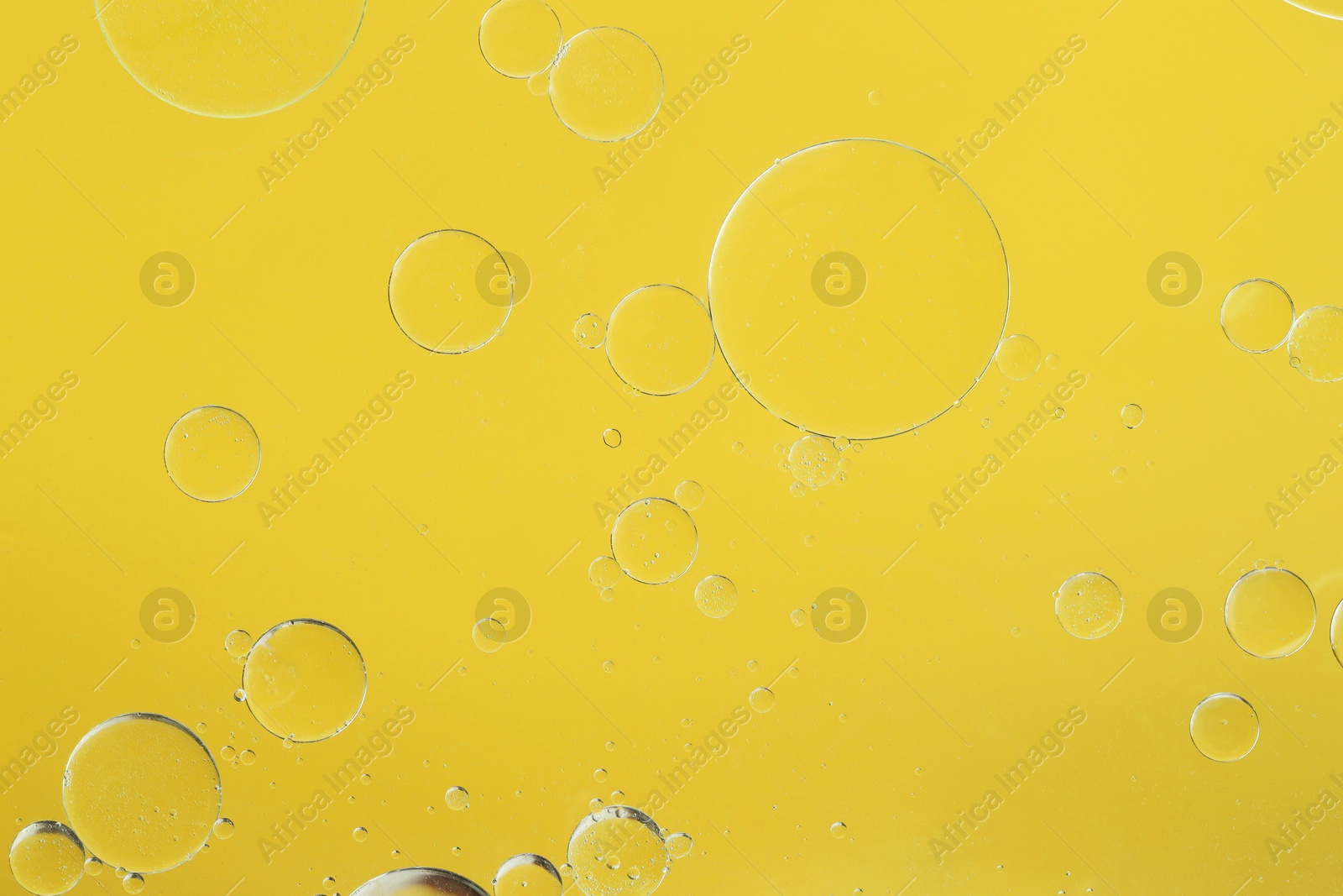 Photo of Sample of cosmetic oil on yellow background, macro view