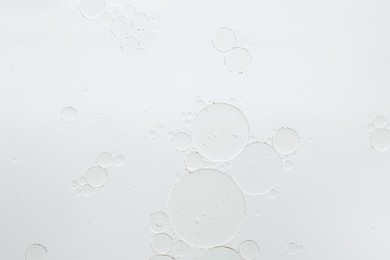 Essential oil bubbles on white background, macro view. Cosmetic product