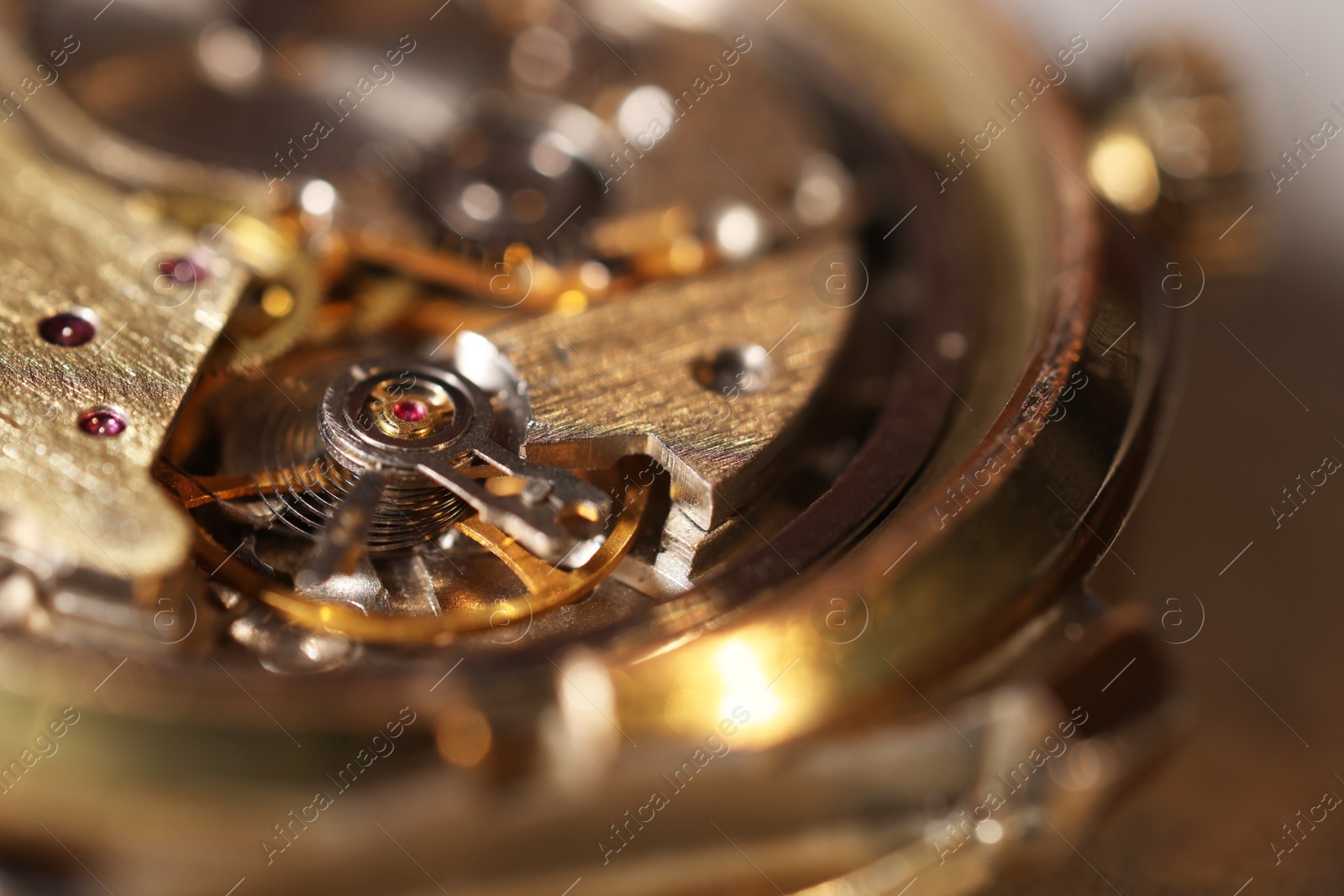 Photo of Mechanism of vintage wrist watch on light background, closeup