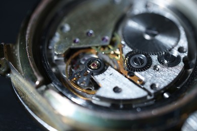 Mechanism of vintage wrist watch on black background, closeup