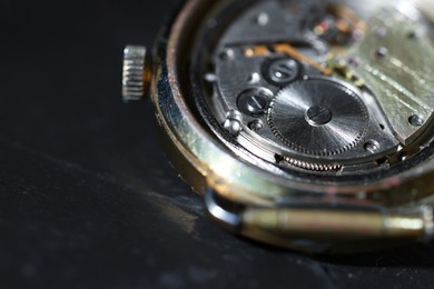 Photo of Mechanism of vintage wrist watch on black background, closeup