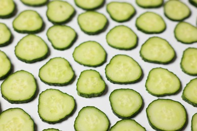 Photo of Slices of fresh cucumbers on white background