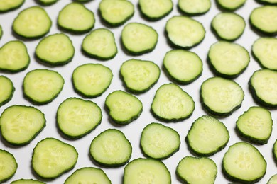 Photo of Slices of fresh cucumbers on white background