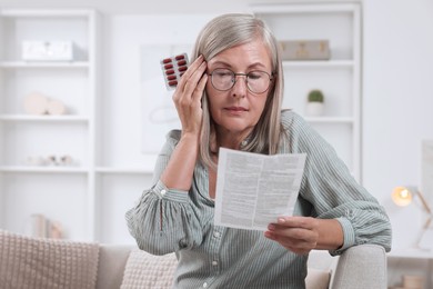 Senior woman with pills reading medicine instruction at home, space for text