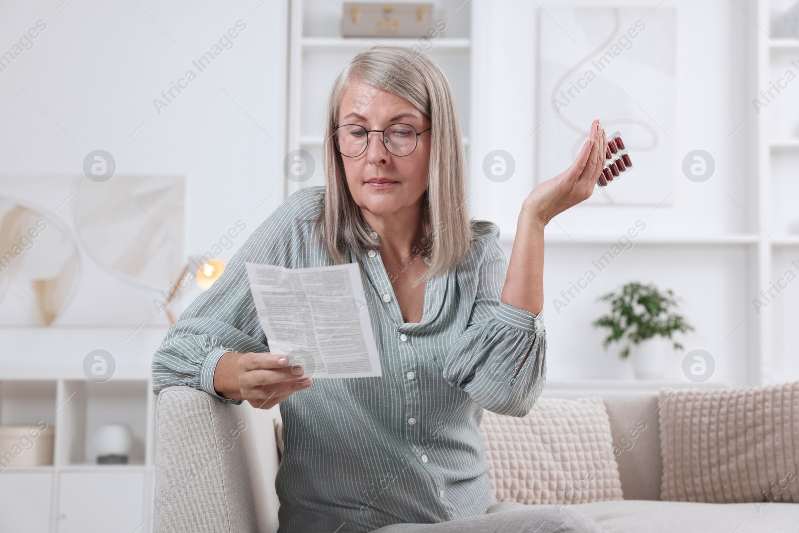 Photo of Senior woman with pills reading medicine instruction at home