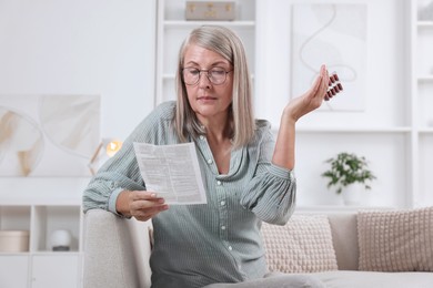 Senior woman with pills reading medicine instruction at home