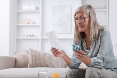 Senior woman with pills reading medicine instruction at home