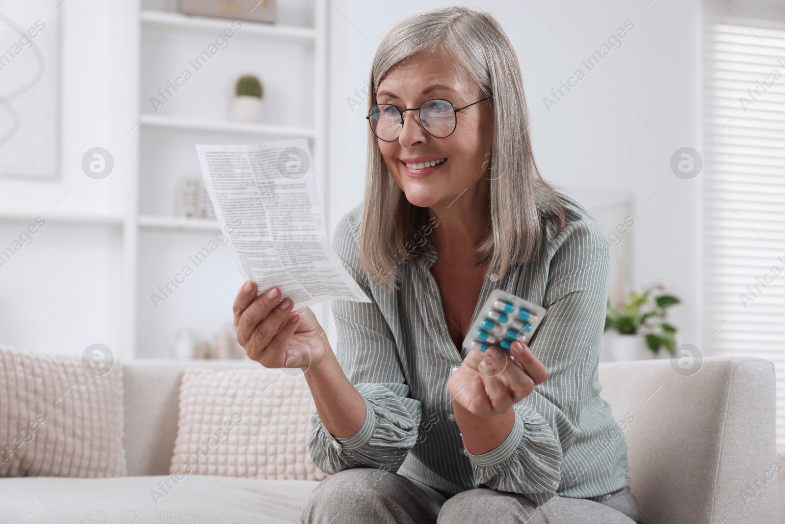 Photo of Senior woman with pills reading medicine instruction at home