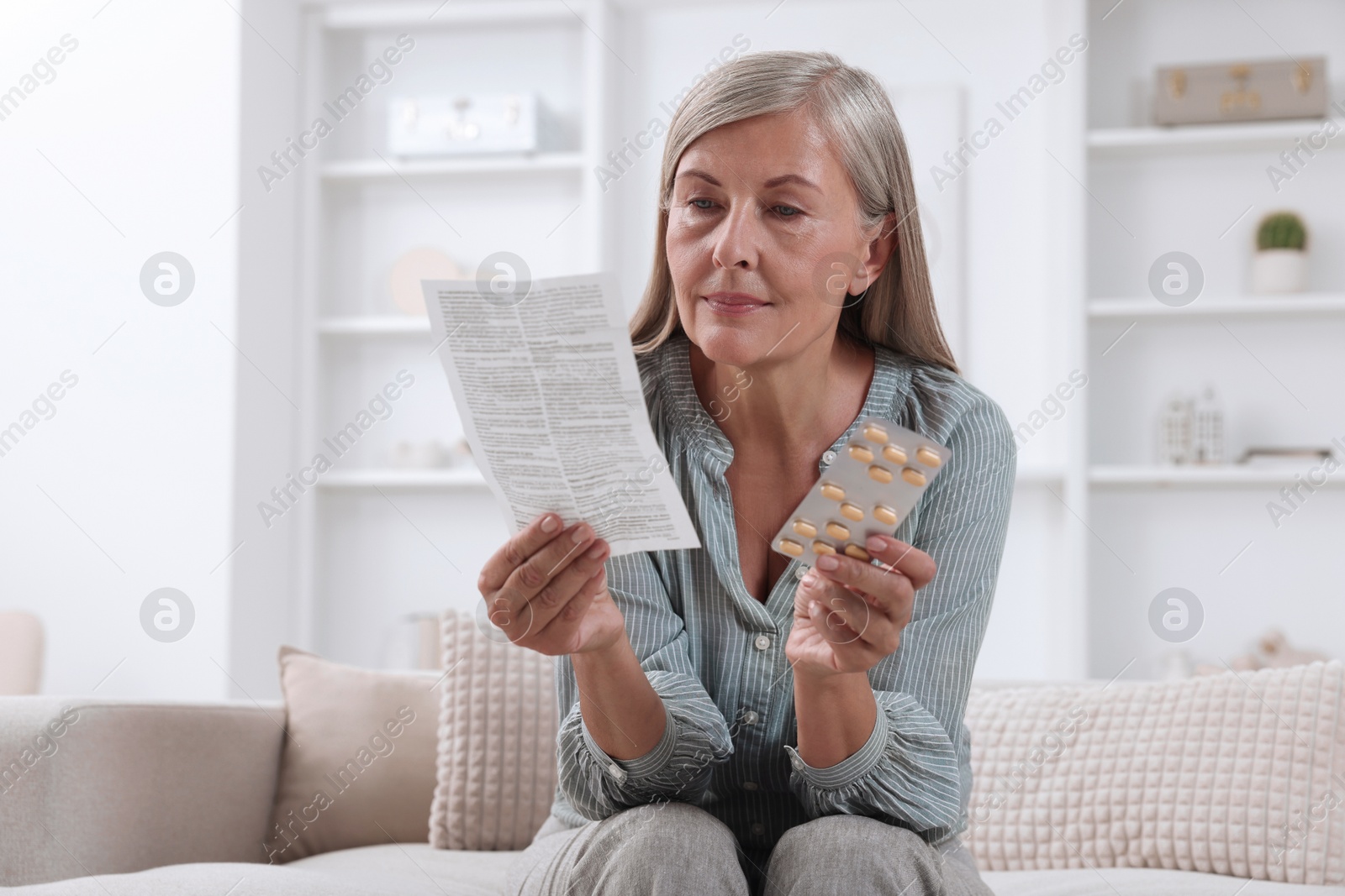 Photo of Senior woman with pills reading medicine instruction at home