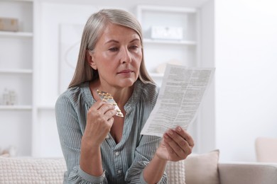 Senior woman with pills reading medicine instruction at home