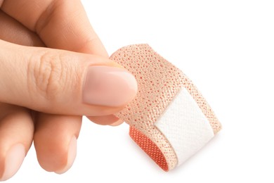 Photo of Woman putting medical adhesive bandage on white background, closeup