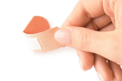 Photo of Woman putting medical adhesive bandage on white background, closeup