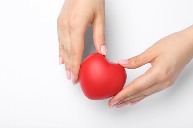 Photo of Woman with red decorative heart at white table, top view