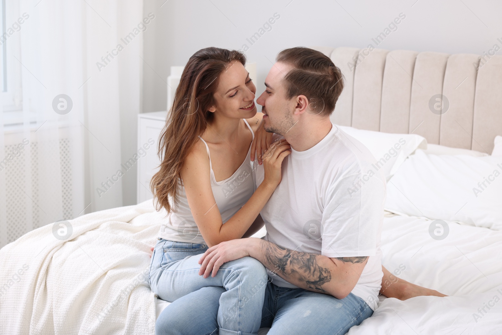 Photo of Happy couple spending time together on bed at home