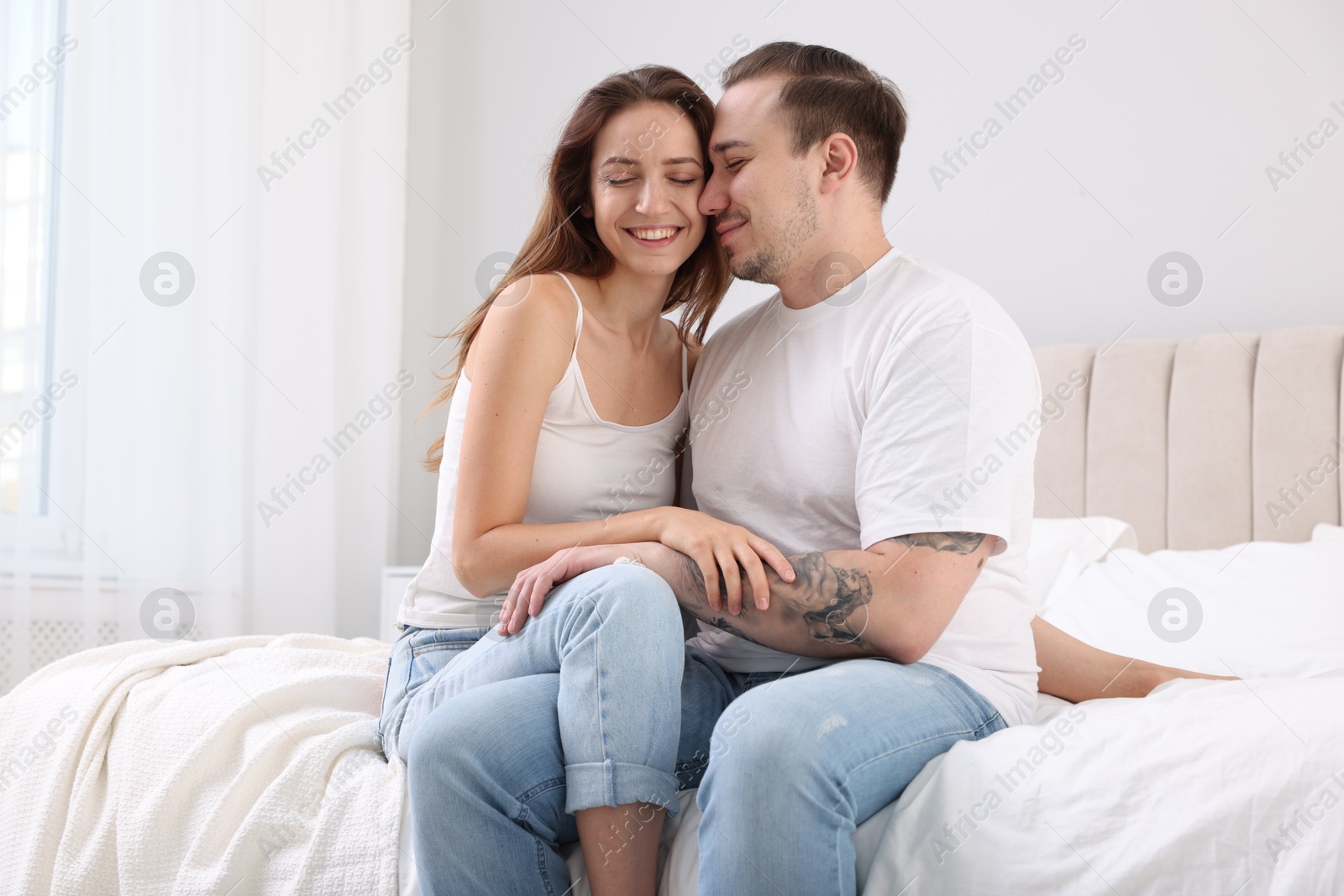 Photo of Happy couple spending time together on bed at home