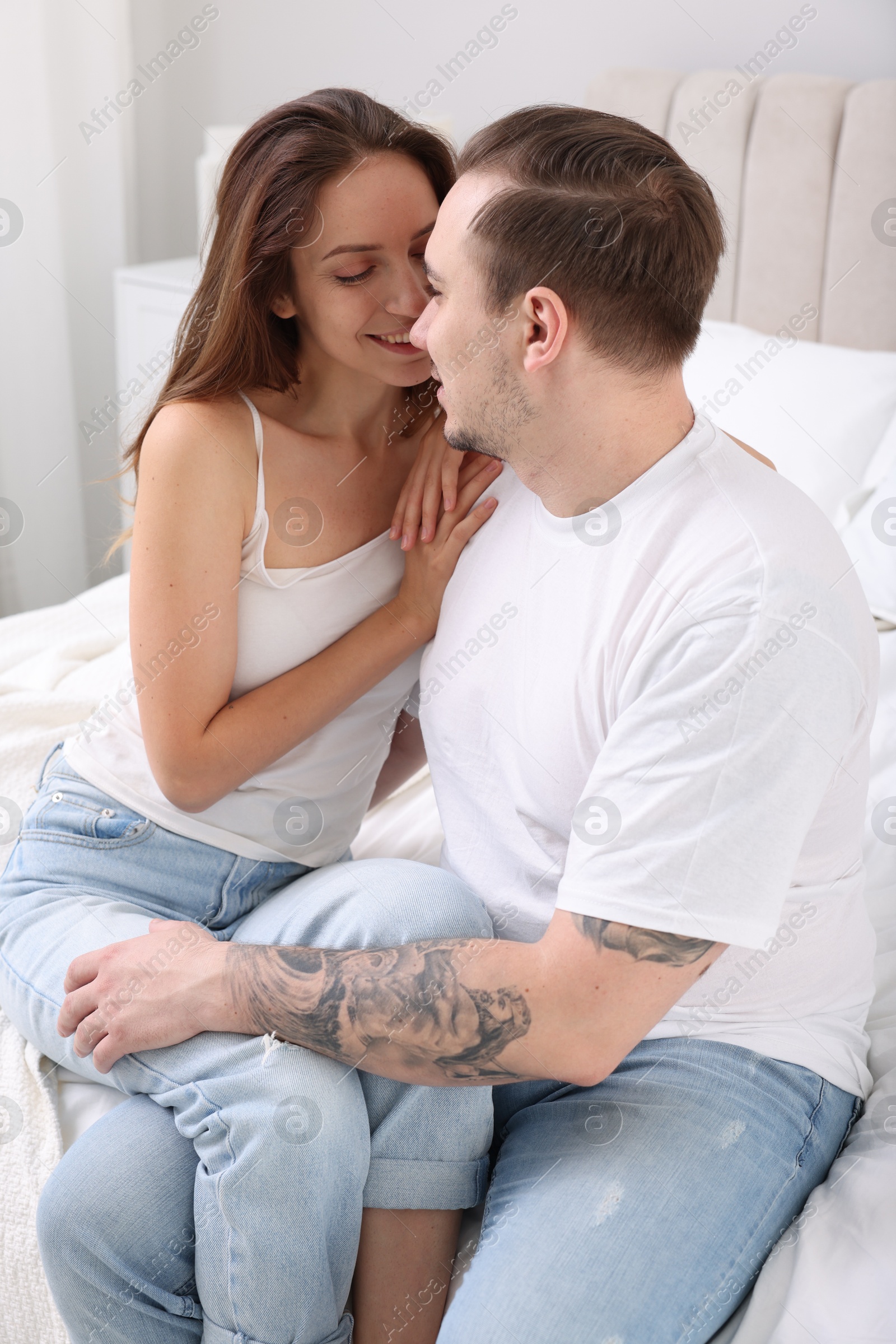 Photo of Happy couple spending time together on bed at home