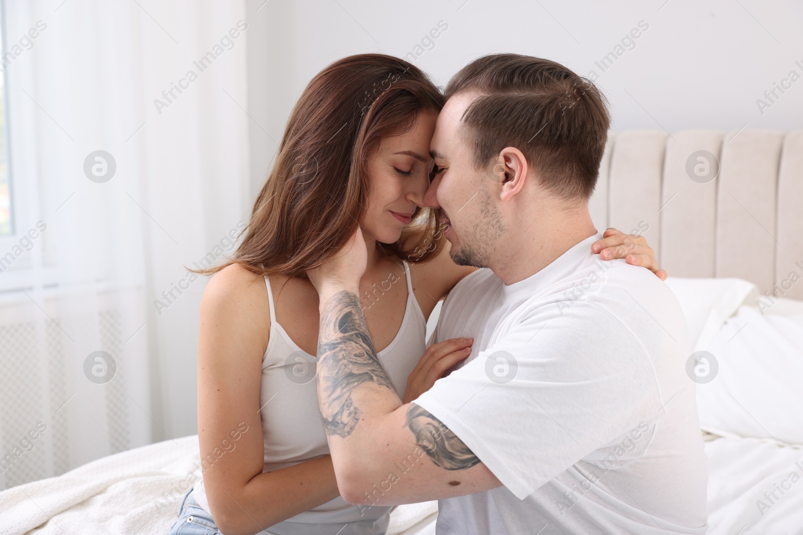 Photo of Cute couple spending time together on bed at home