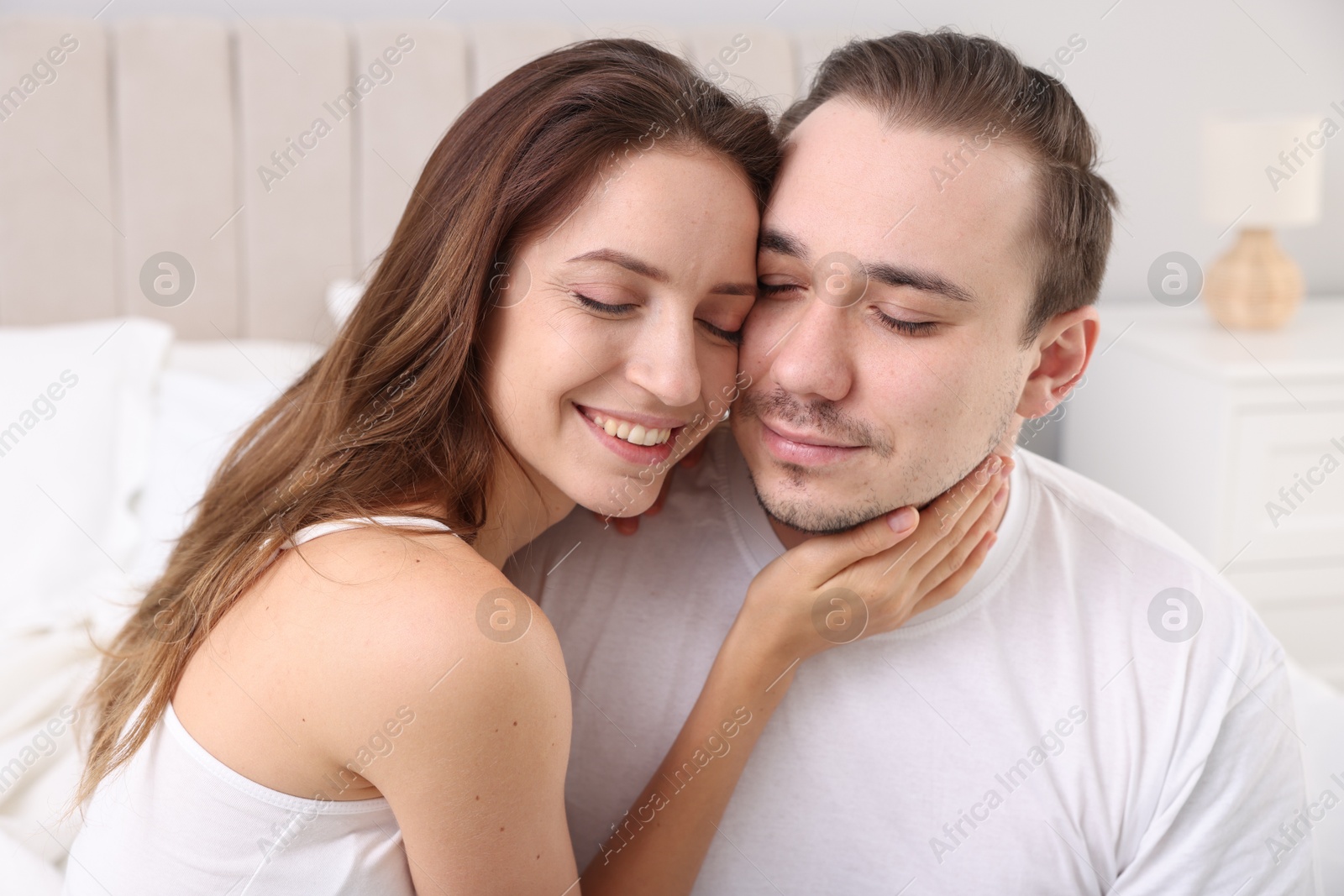 Photo of Happy couple spending time together on bed at home