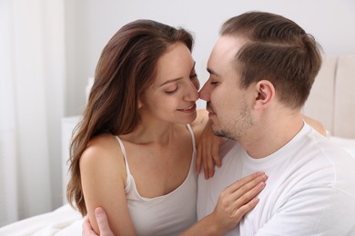 Photo of Happy couple spending time together on bed at home