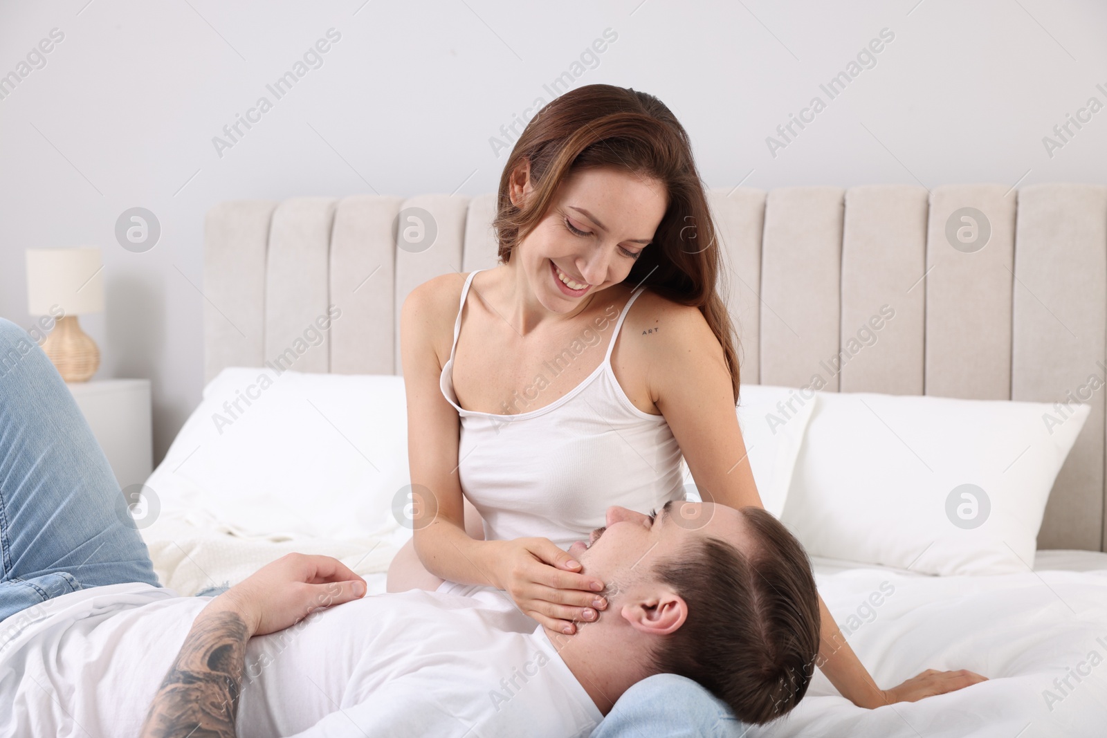 Photo of Happy couple spending time together on bed at home