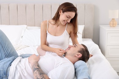 Happy couple spending time together on bed at home