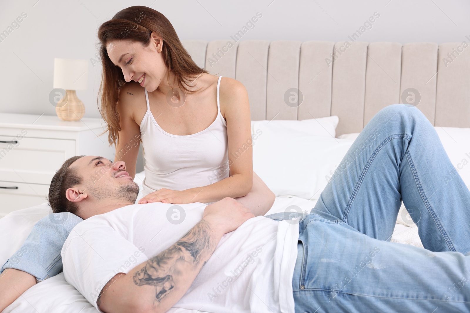 Photo of Happy couple spending time together on bed at home