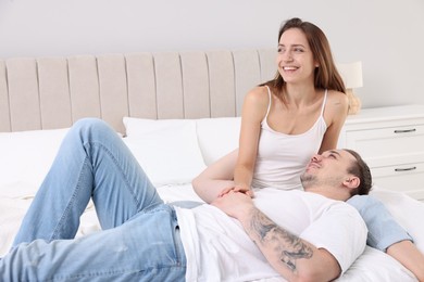 Photo of Happy couple spending time together on bed at home