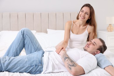 Happy couple spending time together on bed at home