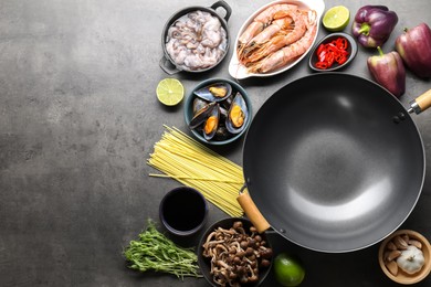 Photo of Ingredients for wok on grey table, flat lay. Space for text