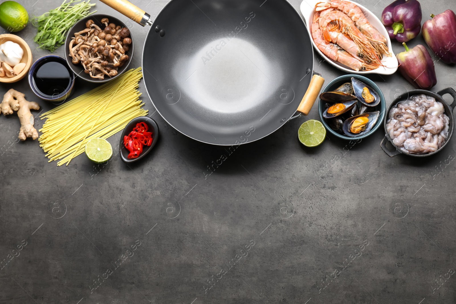 Photo of Ingredients for wok on grey table, flat lay. Space for text