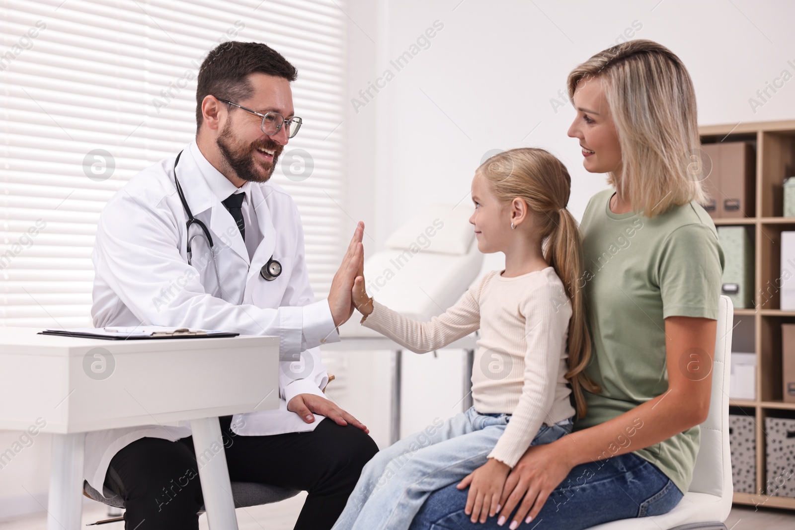 Photo of Mother and her little daughter having appointment with doctor in hospital