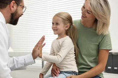 Photo of Mother and her little daughter having appointment with doctor in hospital