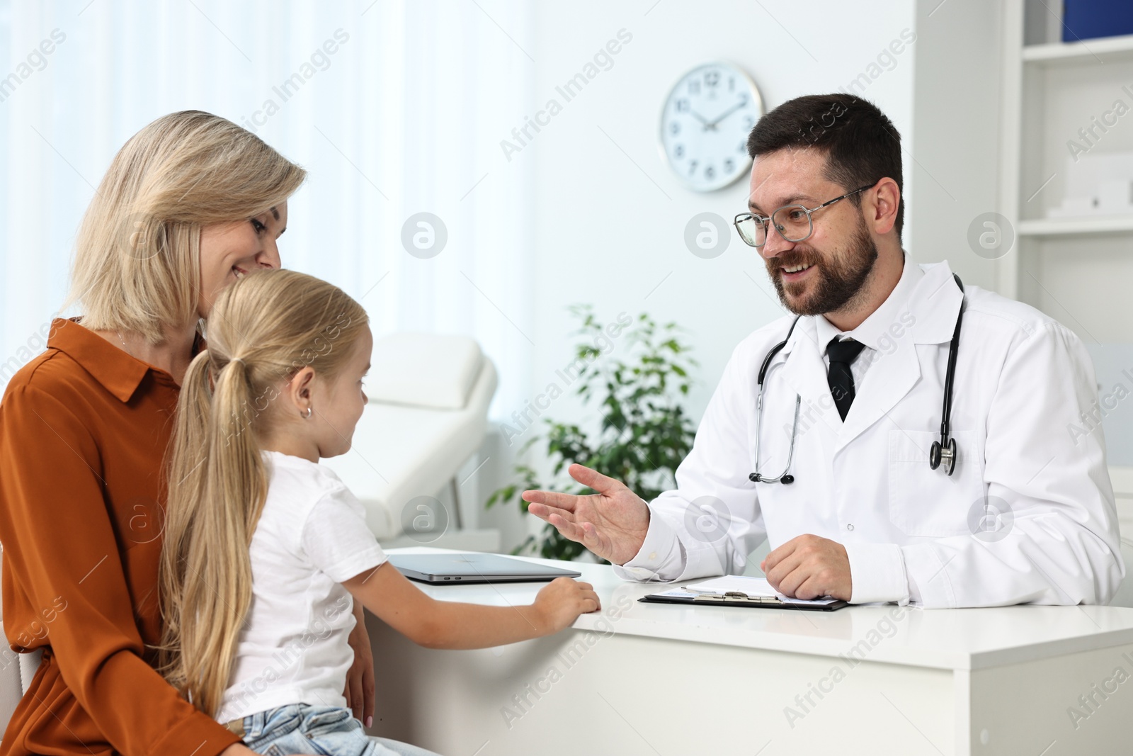 Photo of Doctor consulting little girl and her mother in hospital